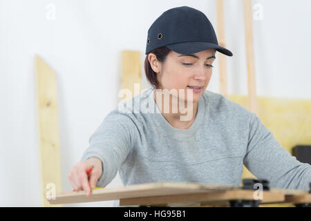 Ritratto di donna felice falegname redazione nuovo progetto in officina Foto Stock