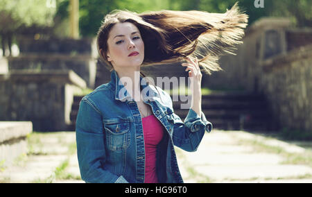 Ragazza giovane con battenti capelli al vento nella molla. In stile vintage, tonificante. Foto Stock