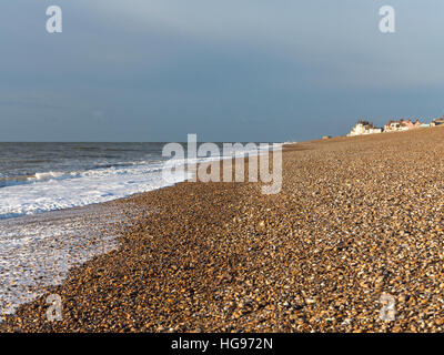 Una lunga distesa di spiaggia di ciottoli con la città balneare di Aldeburgh Suffolk in Inghilterra a distanza Foto Stock