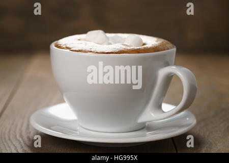 Tazza di cappuccino con marshmallow sul tavolo di legno Foto Stock