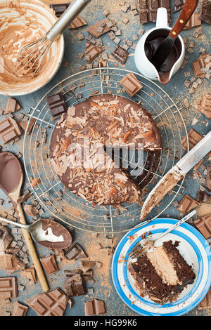 Un pasticcio di cioccolato. Torta al cioccolato, barre, pezzi e pattern di polvere sull'ardesia Foto Stock