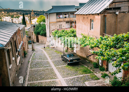 Tbilisi, Georgia - 20 Maggio 2016: vista dall'alto di discesa acciottolata strada stretta con Nero parcheggiata Volga GAZ, Retro rarità auto nei pressi del residenziale privato Foto Stock