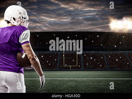 Giocatore di calcio con un viola uniforme su un Stadium. Foto Stock