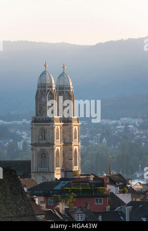 Le torri gemelle di Zurigo medievale della cattedrale Grossmunster al tramonto Foto Stock