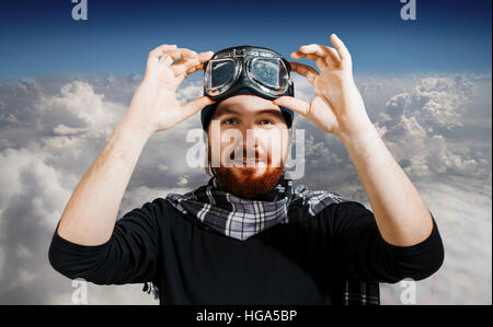 Retrò Boy pilota. L uomo indossa occhiali, immagine di fantasia di aviatore contro il cielo Foto Stock