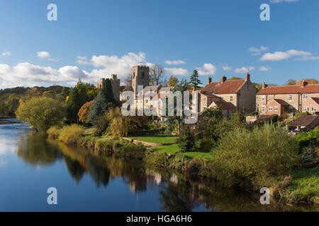 Pittoresca Tanfield West village dal Fiume Ure, North Yorkshire, Inghilterra - luminoso cielo blu si riflette sull'acqua. Foto Stock