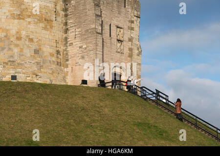 Ingresso alla Torre di Clifford - i visitatori scattano foto e posano presso le storiche rovine medievali del castello in cima a una collina, simbolo di York, North Yorkshire, Inghilterra, Regno Unito. Foto Stock