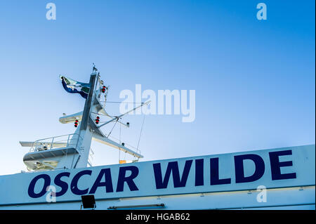 Il nome del traghetto per auto 'Oscar Wilde' scritta sulla nave con la radio e la torre del radar su un blu chiaro giorno con copia spazio. Foto Stock