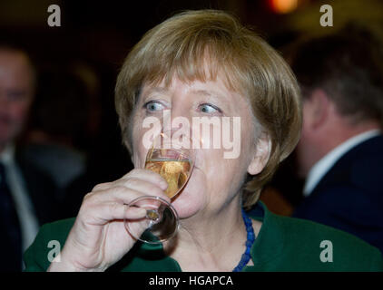 Trinwillershagen, Germania. Il 6 gennaio, 2017. Il cancelliere tedesco Angela Merkel (CDU) bere un bicchiere di champagne a un nuovo anno di ricezione del Landrat del distretto Vorpommern-Ruegen, in Trinwillershagen, Germania, 6 gennaio 2017. Merkel ha rappresentato il Stralsund-Greifswald-Ruegen-Vorpommern circoscrizione nel Bundestag dal 1990. Foto: Stefan Sauer/dpa-Zentralbild/dpa/Alamy Live News Foto Stock