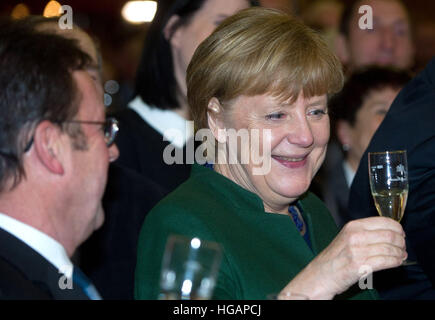 Trinwillershagen, Germania. Il 6 gennaio, 2017. Il cancelliere tedesco Angela Merkel (CDU) bere un bicchiere di champagne a un nuovo anno di ricezione del Landrat del distretto Vorpommern-Ruegen, in Trinwillershagen, Germania, 6 gennaio 2017. Merkel ha rappresentato il Stralsund-Greifswald-Ruegen-Vorpommern circoscrizione nel Bundestag dal 1990. Foto: Stefan Sauer/dpa-Zentralbild/dpa/Alamy Live News Foto Stock