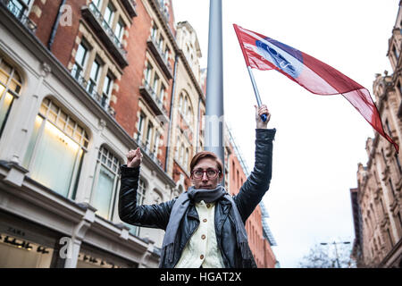 Londra, Regno Unito. Il 7 gennaio, 2017. Un sostenitore del Regno voci del commercio mondiale unione detiene il sindacato la bandiera a una protesta al di fuori di Harrods contro il negozio di ritenzione fino a 75% del 12,5% di tassa di servizio aggiunto per le fatture di diners nei suoi ristoranti di lusso. Credito: Mark Kerrison/Alamy Live News Foto Stock