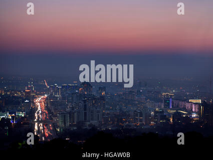Bagliore rosso dopo il tramonto su Almaty con highrise torri e Al Farabi Avenue Kazakistan Foto Stock