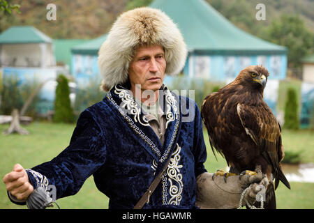 Professional trainer con Golden Eagle a Sunkar Raptor Centre di Alma Arasan Gorge Almaty Kazakhstan Foto Stock