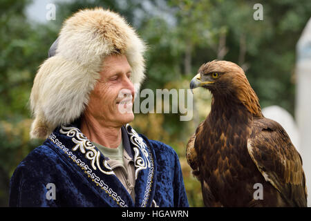 Professional trainer sorridente al Golden Eagle a Sunkar Raptor Centre di Alma Arasan Gorge Almaty Kazakhstan Foto Stock