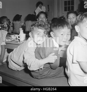 Un ragazzo Japanese-American ottiene un abbraccio dal suo pal durante la pausa pranzo, aprile 1942. Foto Stock