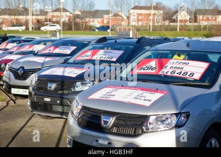 Dacia veicoli scontati, auto berlina di seconda mano allineati su piazzale garage auto usate con adesivi Apr 'vendita reale' Deal, Preston, Lancashire, Regno Unito. Foto Stock