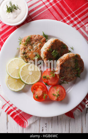 Hot torte di pesce con salsa di aneto sul tavolo di close-up. verticale vista superiore Foto Stock