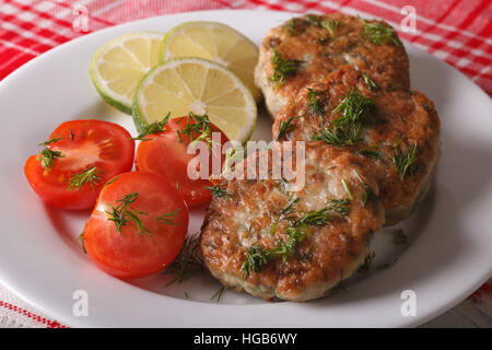 Cotolette dal bianco i filetti di pesce con erbe di close-up su una piastra bianca orizzontale. Foto Stock