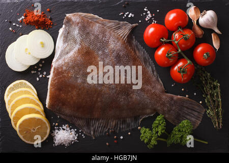 Crudo fresco passera di mare con ingredienti su una scheda di ardesia closeup. vista orizzontale dal di sopra Foto Stock