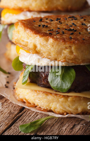 Succosa ramen burger con uovo vicino sul tavolo. In verticale Foto Stock