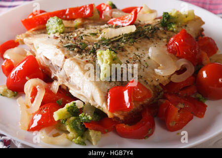 La Passera di mare al forno con Peperoni e broccoli close-up su una piastra bianca orizzontale. Foto Stock