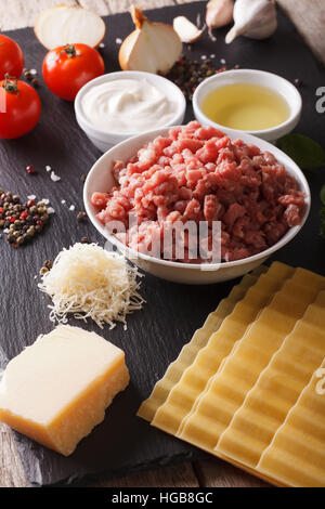 Cucina Italiana lasagne sul tavolo. Ingredienti closeup verticale. Foto Stock