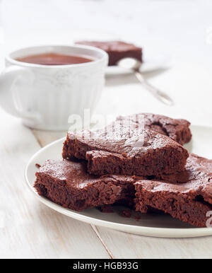 I biscotti su una piastra, una tazza di caffè in bianco sullo sfondo di legno Foto Stock
