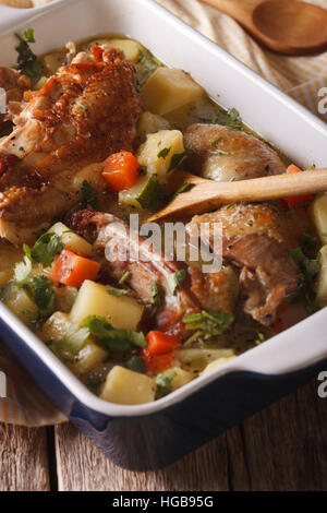 Gustoso stufato di pollo con patate, le zucchine e le carote in un piatto di close-up verticale. Foto Stock