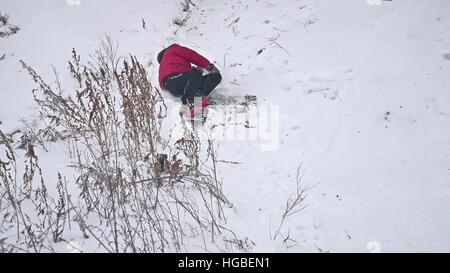Sport ragazzo snowboard caduta in rotolamento sulla neve con vacanze inverno Foto Stock