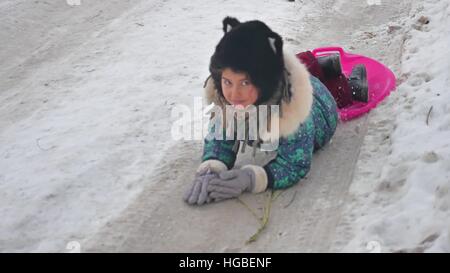 Bambina neve Equitazione laminazione scorre giù per le colline, Inverno Vacanze invernali Foto Stock