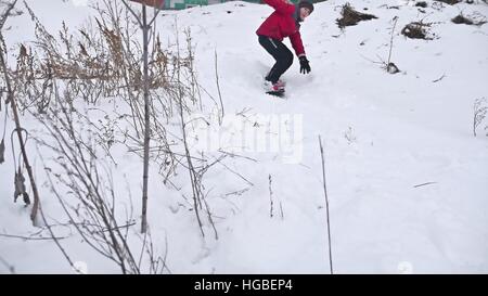Ragazzo snowboard caduta in rotolamento sulla neve con le vacanze sport inverno Foto Stock