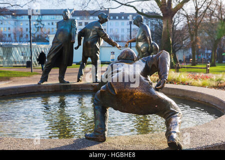 Aachen, Germania - 27 dicembre 2016: statua in bronzo di nome di circolazione del denaro in Aachen, con persone non identificate. Aachen è una città termale nel NRW e stato Foto Stock