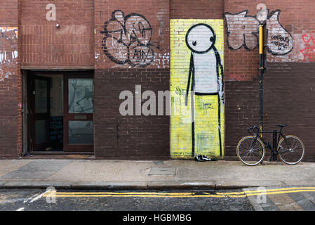 Street murale di artista Stik o un alto Figura che guarda pensieroso a Londra Foto Stock