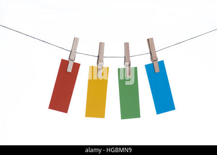 Appendere carte - quattro pezzi di carta colorata appesi da una linea da mollette Foto Stock