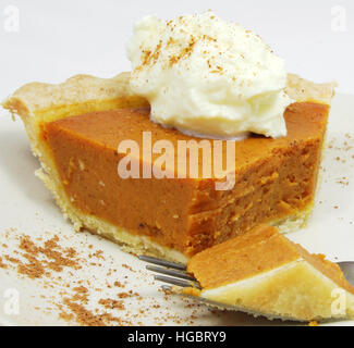In parte mangiato fetta di torta di zucca con panna montata. Foto Stock