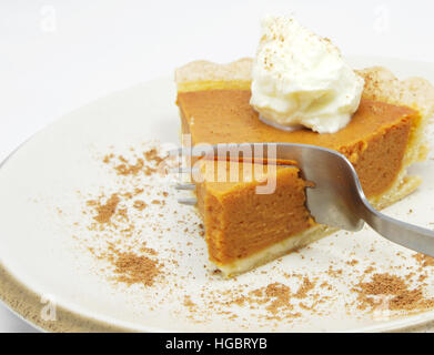 Mangiare una fetta di torta di zucca con panna montata. Foto Stock