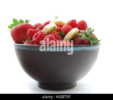 Insalata di frutta su sfondo bianco. Fragola, lampone e banana in una ciotola. Foto Stock