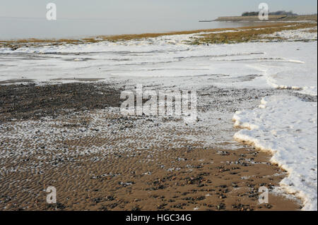 Nuvole grigie e vista mare di ghiaccio sulla spiaggia di sabbia e a saltmarsh east end di nonna Bay, guardando ad ovest, Fairhaven, Lytham, Lancashire, Regno Unito Foto Stock