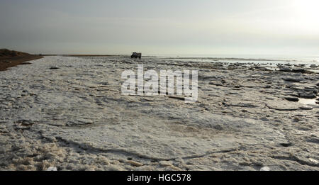 Nuvole grigie, vista guardando verso est, larga e lunga piatta distesa di terra-mare veloce blocchi di ghiaccio sulla spiaggia a est di St Annes, Lancashire, Regno Unito Foto Stock