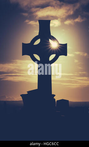 Sun Glinting attraverso una croce Celtica Foto Stock