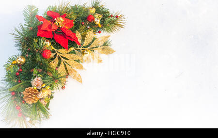 Vacanze di Natale faux poinsettia ghirlanda di pino con copyspace bianco. Foto Stock