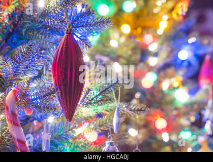 Addobbi per l'albero di Natale. Rosso brillante vacanze di Natale addobbi appesi da rami su una piccola finta struttura interna. Foto Stock