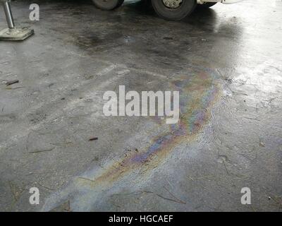 Fuoriuscita di olio arcobaleno di colori su asfalto Foto Stock