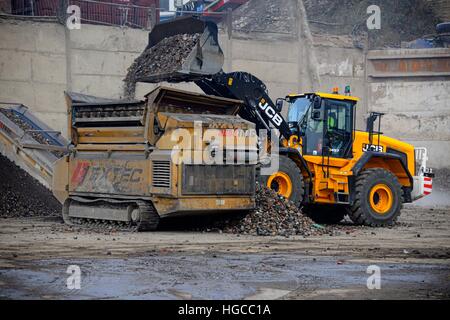 JCB 457 caricando un Extec Robotrac frantoio Foto Stock