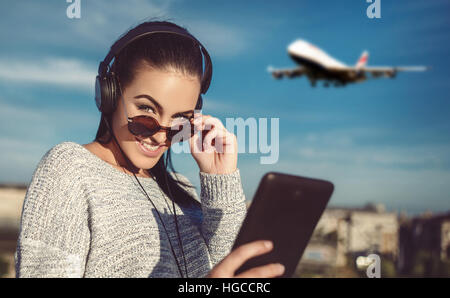 Giovane donna ordinazione di biglietto di aria compressa da esterno, shopping online, tecnologia wireless Foto Stock