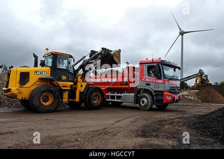 JCB 435s il riempimento J C sfere e figli Mercedes-Benz Arocs tre-assale carrello del cassone ribaltabile Foto Stock