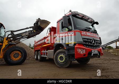 JCB 435s il riempimento J C sfere e figli Mercedes-Benz Arocs tre-assale carrello del cassone ribaltabile Foto Stock