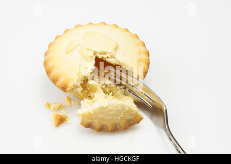 Piccola fetta di torta di mele singoli servendo con una forcella taglio in essa su una superficie bianca. Inghilterra, Regno Unito Foto Stock