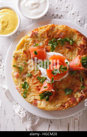 Frittelle di patate con salmone affumicato e salsa su una piastra di close-up. verticale vista superiore Foto Stock