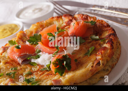 Frittelle di patate con salmone e salsa su una piastra di close-up orizzontale. Foto Stock